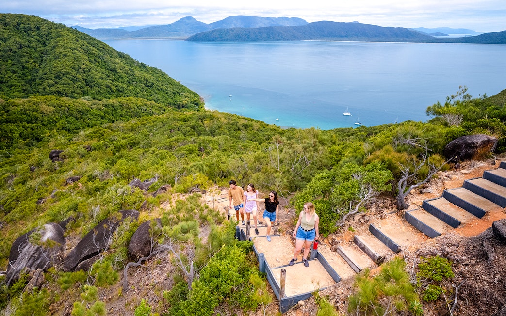 Hikers on a trail overlooking Fitzroy Island and Coral Sea near Cairns, Australia.