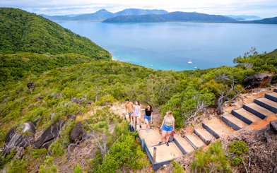 Hikers on a trail overlooking Fitzroy Island and Coral Sea near Cairns, Australia.