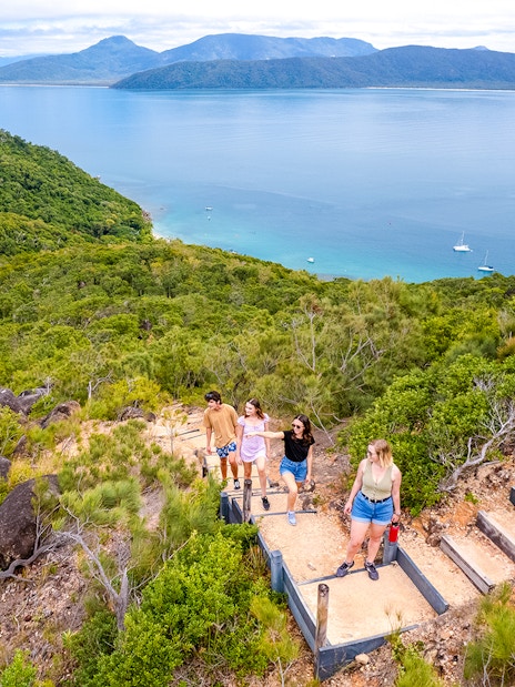 Hikers on a trail overlooking Fitzroy Island and Coral Sea near Cairns, Australia.