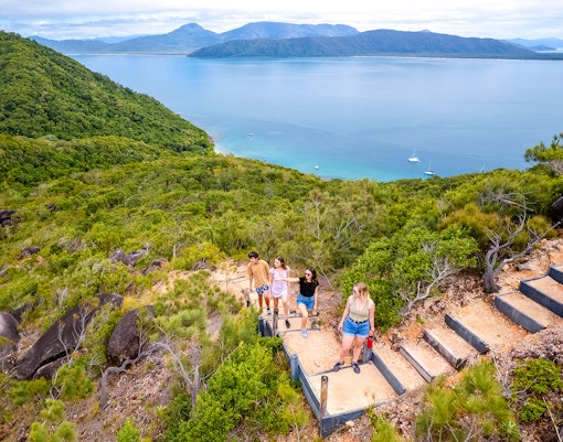 Hikers on a trail overlooking Fitzroy Island and Coral Sea near Cairns, Australia.