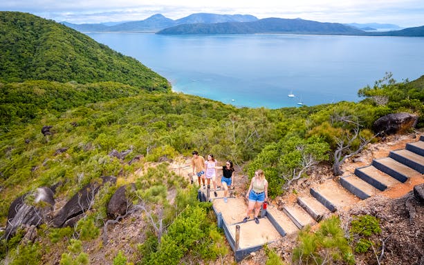 Hikers on a trail overlooking Fitzroy Island and Coral Sea near Cairns, Australia.