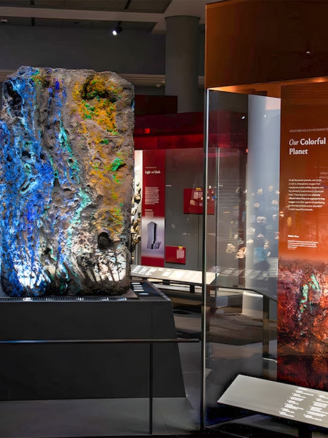Colorful mineral exhibit at a museum, featuring large geodes and vibrant rock samples.