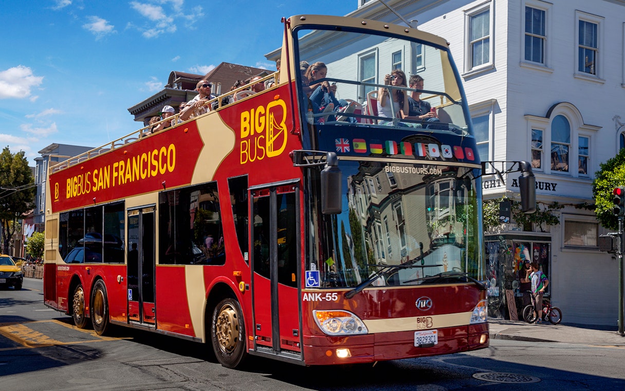 Open-top Big Bus tour in San Francisco passing through a city street.
