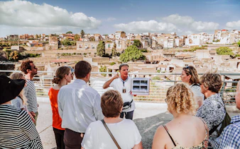 Guide explaining ruins to tour group at Herculaneum, Italy.