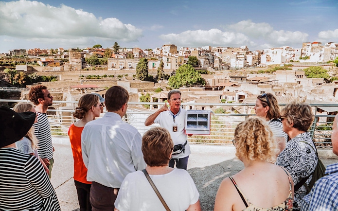 Guide explaining ruins to tour group at Herculaneum, Italy.