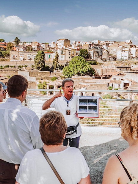 Guide explaining ruins to tour group at Herculaneum, Italy.