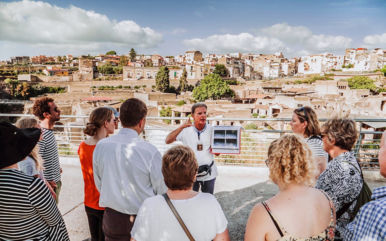Guide explaining ruins to tour group at Herculaneum, Italy.