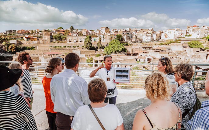 Guide explaining ruins to tour group at Herculaneum, Italy.