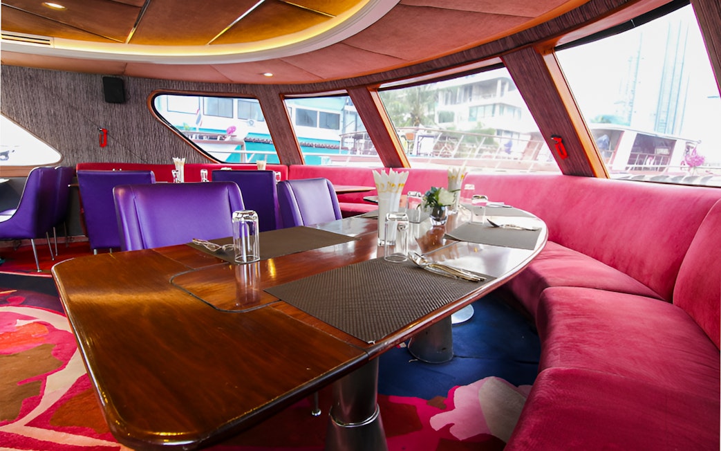 Interior dining area of Grand Pearl River Cruise, Ayutthaya Tour, with elegant seating and table settings.
