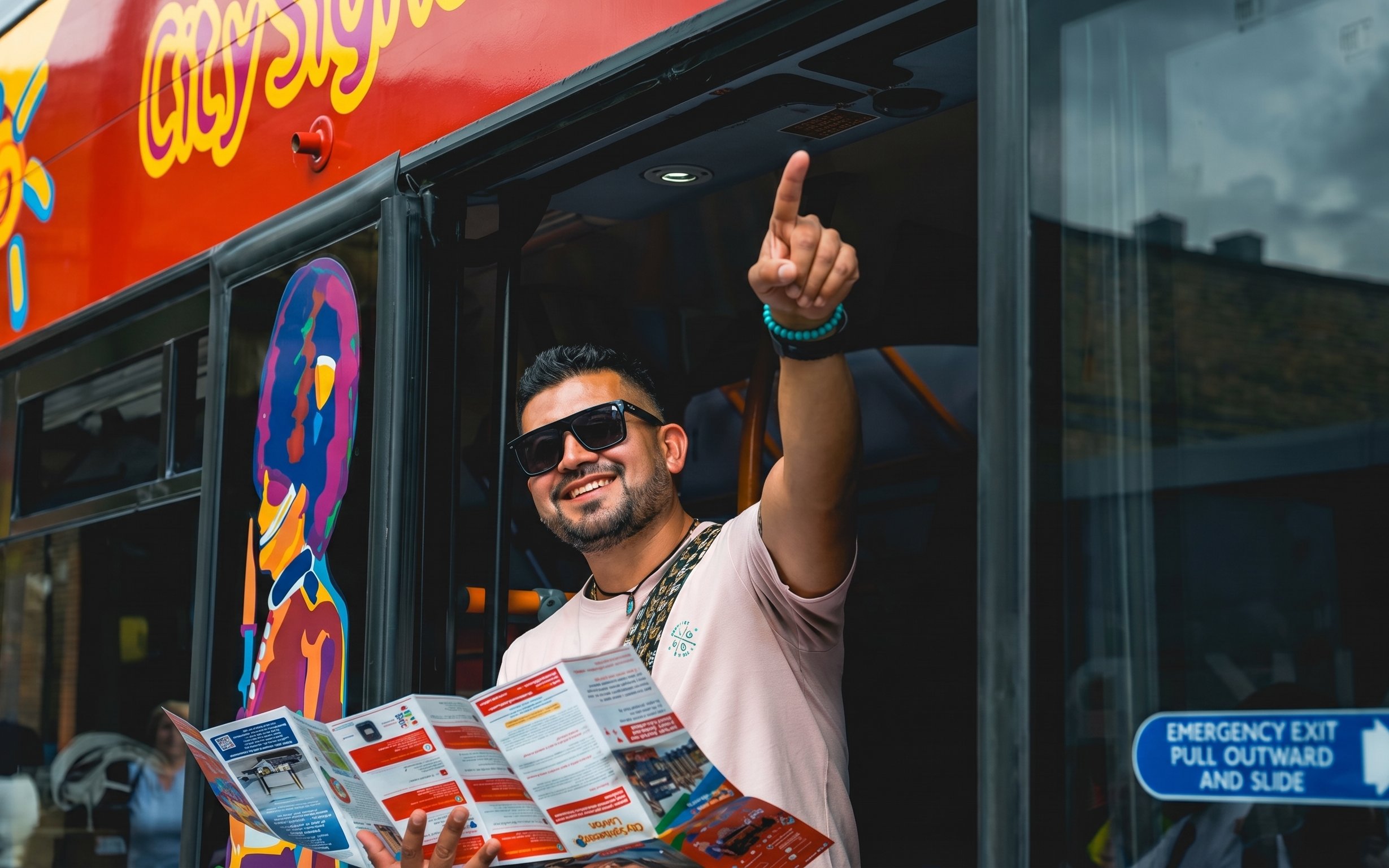 Man holding a map and pointing from a London hop-on hop-off bus.