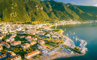 Aerial view of Kamena Vourla coastline with marina and lush mountains.