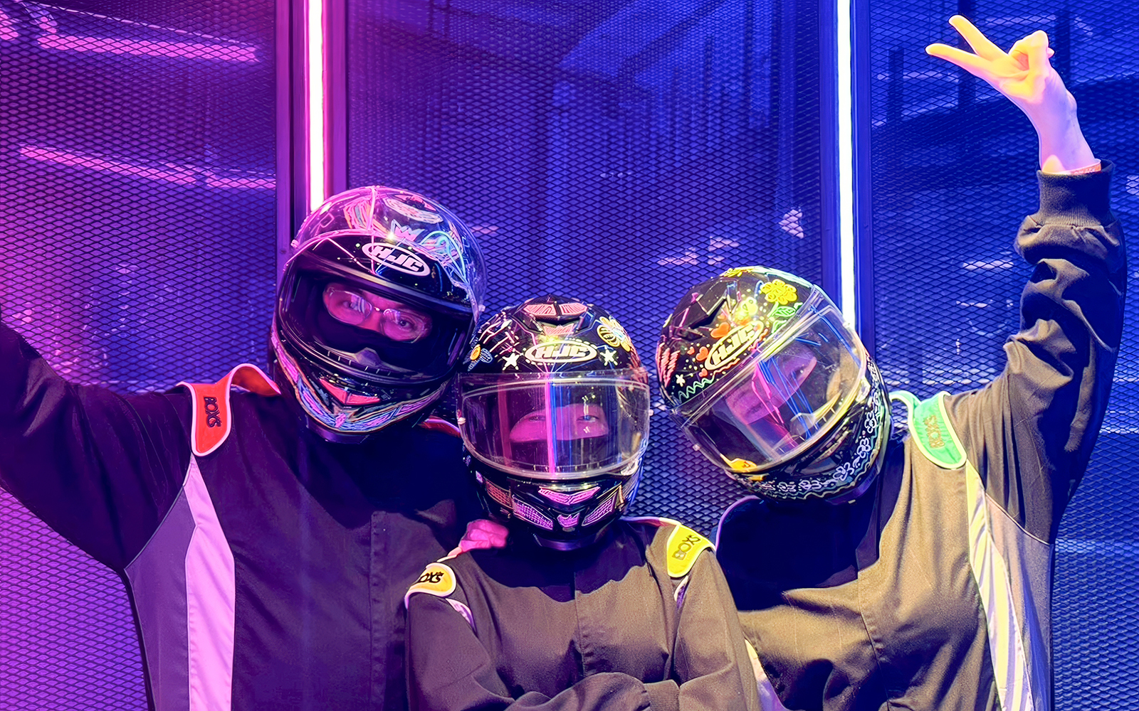 Three people in racing suits and helmets enjoying HyperDrive experience.