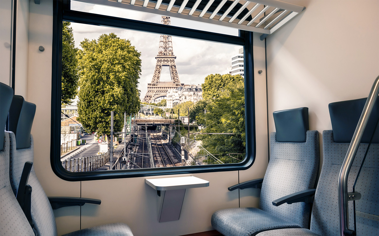 View of Eiffel Tower from train window in Paris near Army Museum.