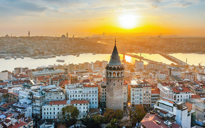 Galata Tower overlooking Istanbul skyline at sunset, Turkey.