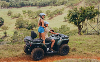 Two people riding a quad bike on a scenic trail in Bel Ombre.