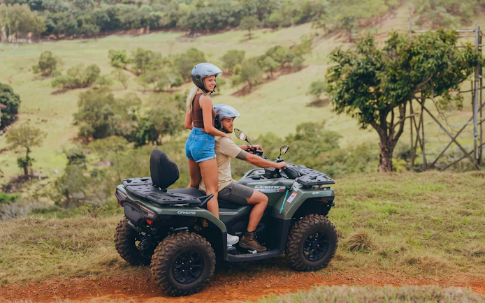 Two people riding a quad bike on a scenic trail in Bel Ombre.