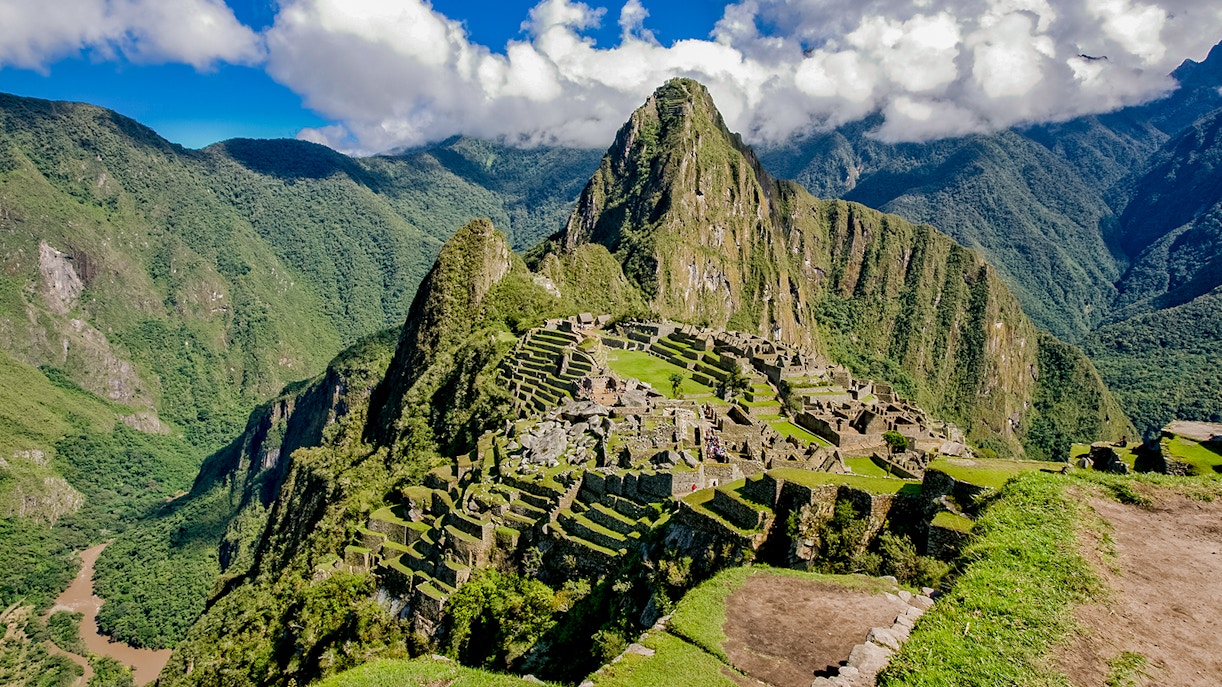 Ancient ruins on the Inca Trail at Pisac, Peru, with mountain backdrop.