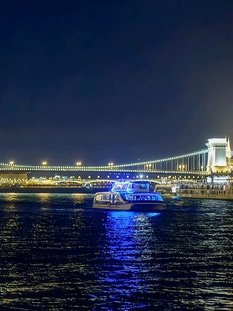 Christmas cruise on the Danube River with Budapest's Chain Bridge illuminated at night.