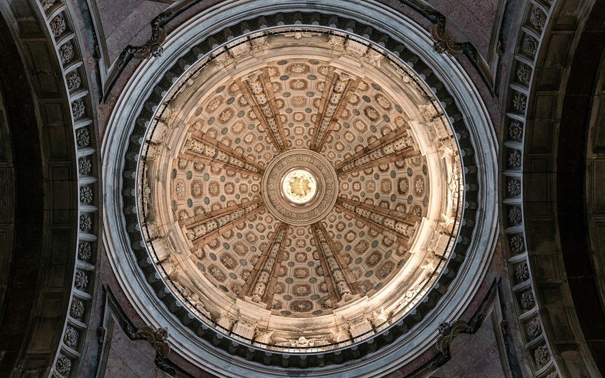 Dome ceiling of the National Palace of Mafra with intricate architectural details.