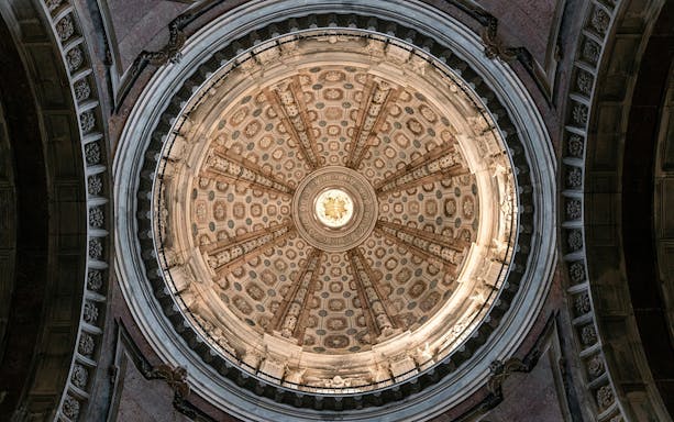 Dome ceiling of the National Palace of Mafra with intricate architectural details.