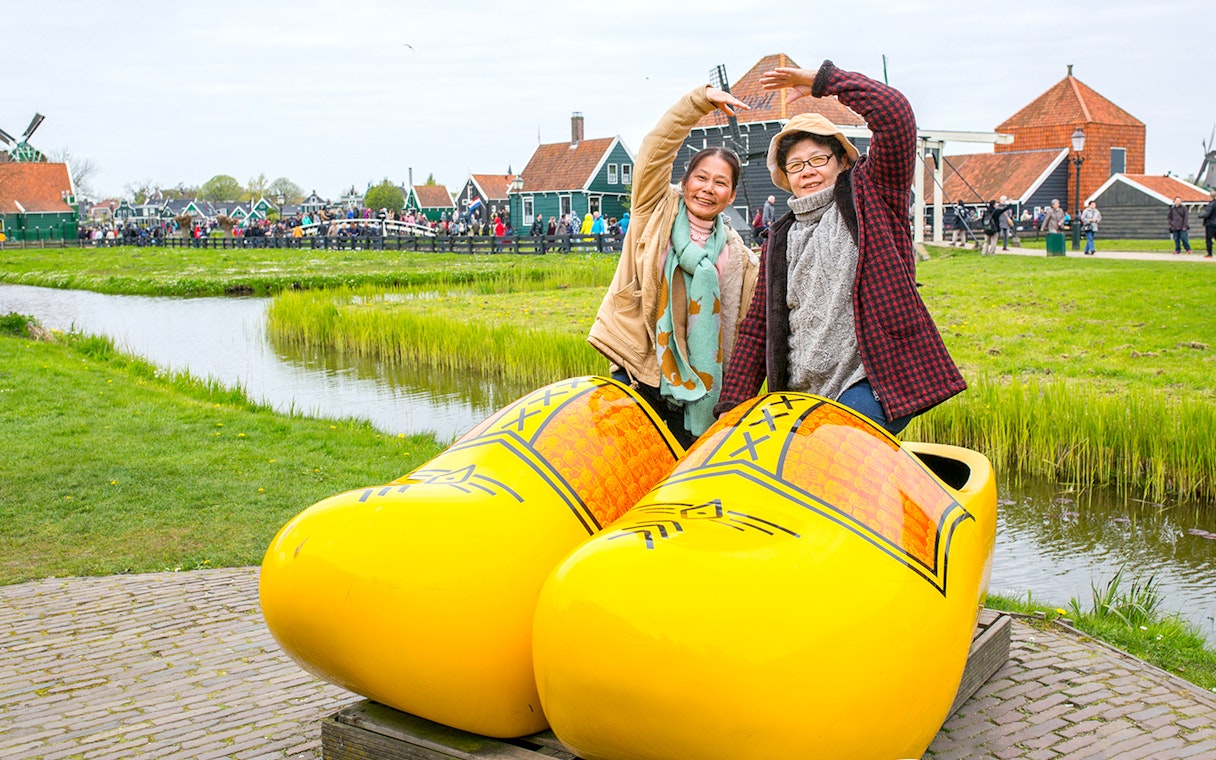 Guests posing in giant yellow clogs at Zaanse Schans, Netherlands.