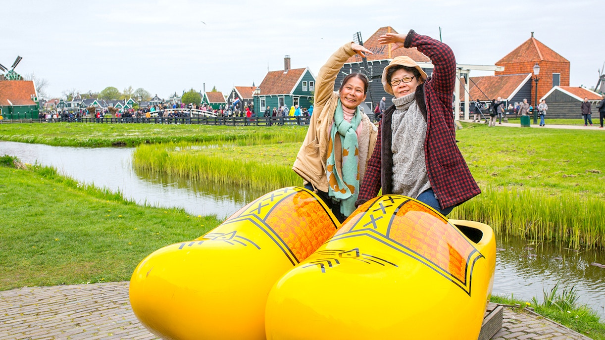 Guests posing in giant yellow clogs at Zaanse Schans, Netherlands.