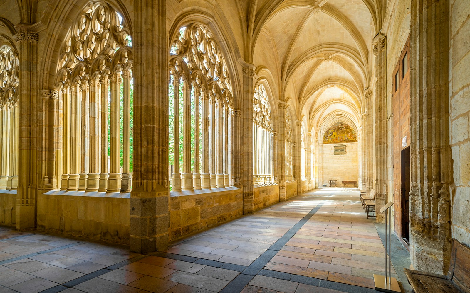 Segovia Cathedral Cloisters with Gothic arches and sunlight streaming through windows.