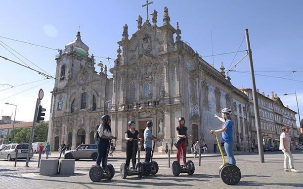 Riders on Segways exploring Porto's historic streets and landmarks during a guided city highlights tour.