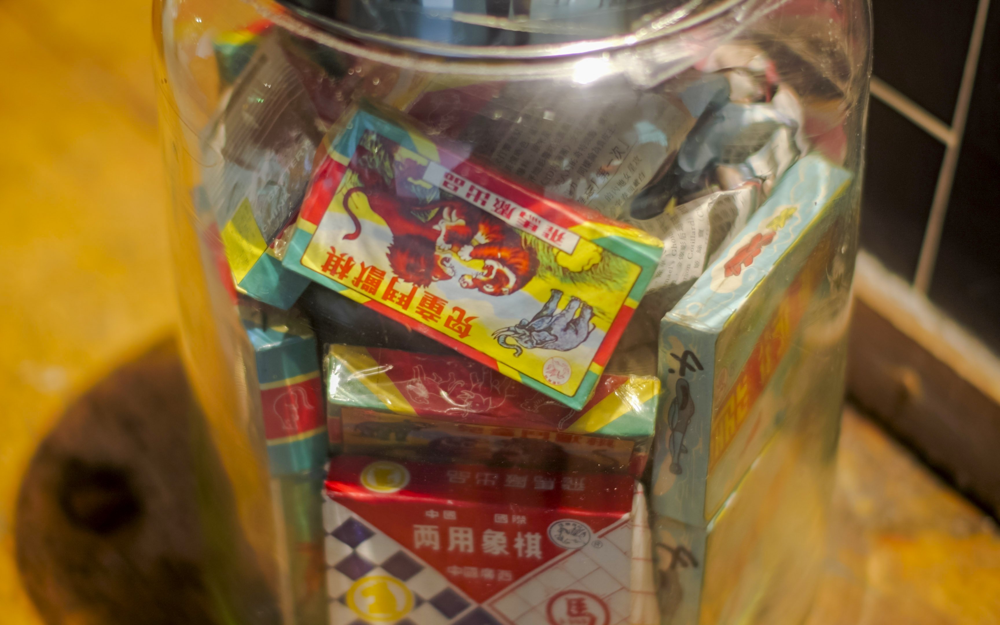 Colorful packaging of traditional Hong Kong snacks in a glass jar at Peak Tram station.
