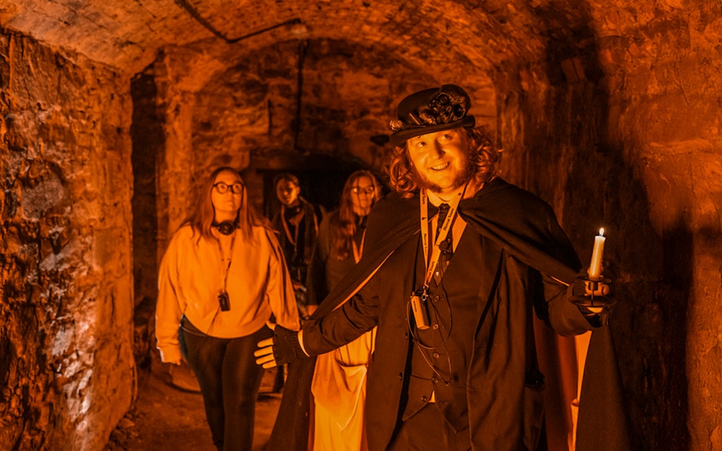 Tour guide leading a group through Blair Street Underground Vaults.