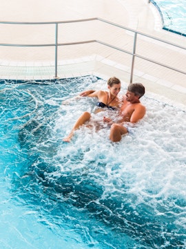 Couple relaxing in a jacuzzi at Chocholow Thermal Baths, Poland.