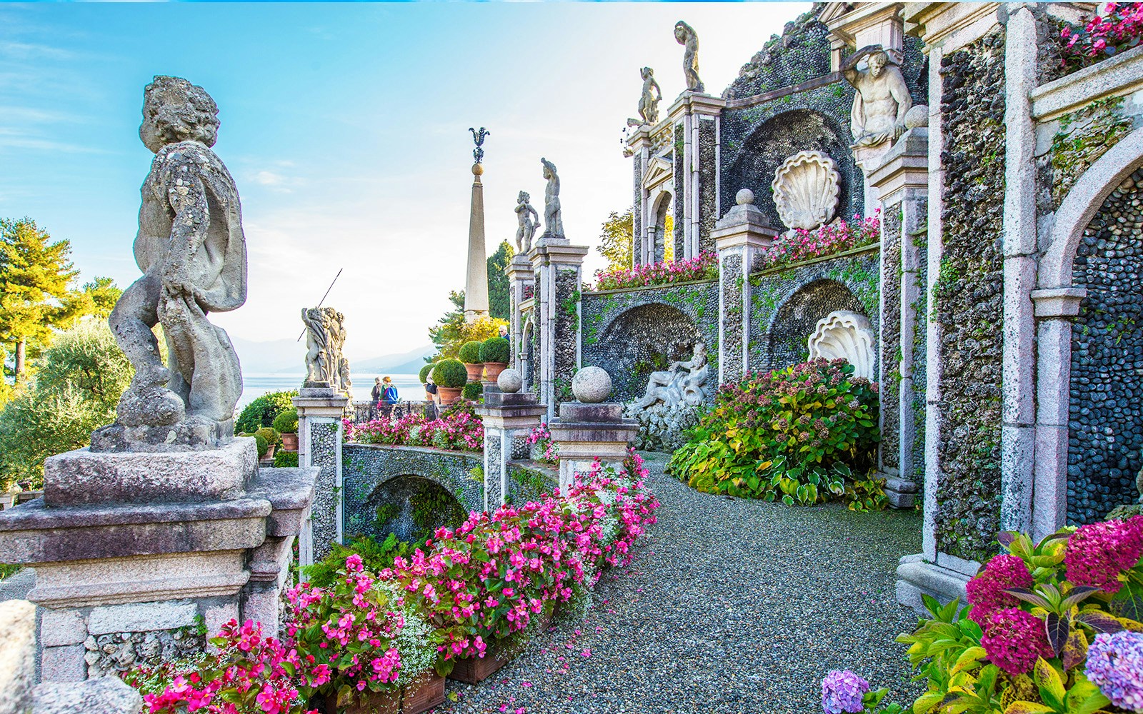 Statues and gardens at Isola Bella, Italy, with lake view in background.