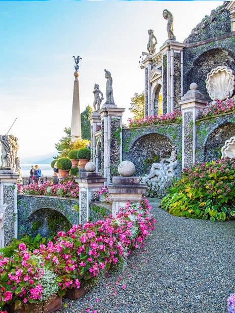 Statues and gardens at Isola Bella, Italy, with lake view in background.