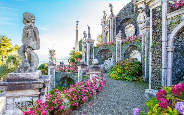 Statues and gardens at Isola Bella, Italy, with lake view in background.
