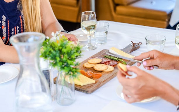 Charcuterie board with cheese and crackers on Swan Valley Wine Cruise table.