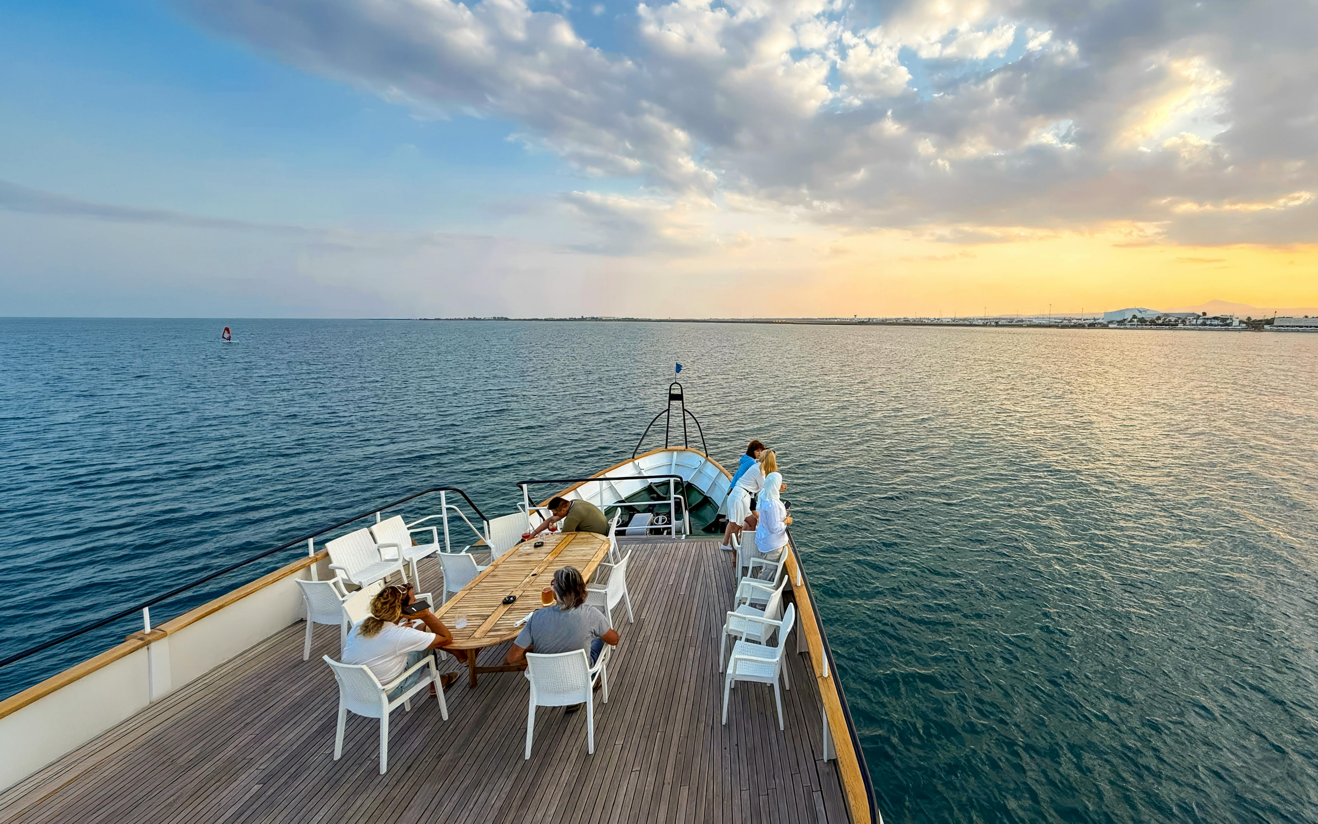 Sunset cruise from Larnaca with people relaxing on a boat deck.