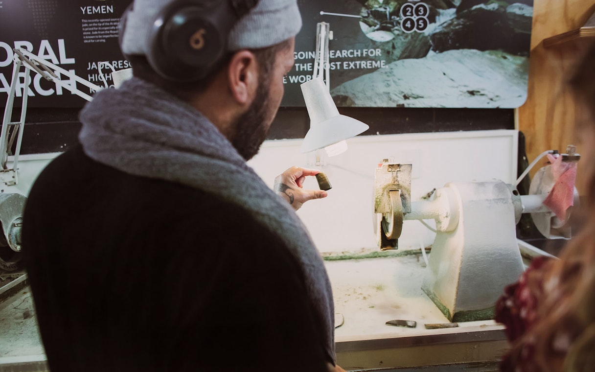 Person examining jade piece during Mountain Jade Highlights Tour.