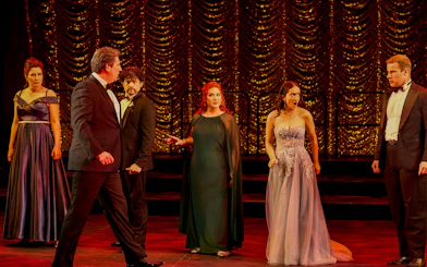 Cast performing a scene from "My Fair Lady" on stage with ornate backdrop.