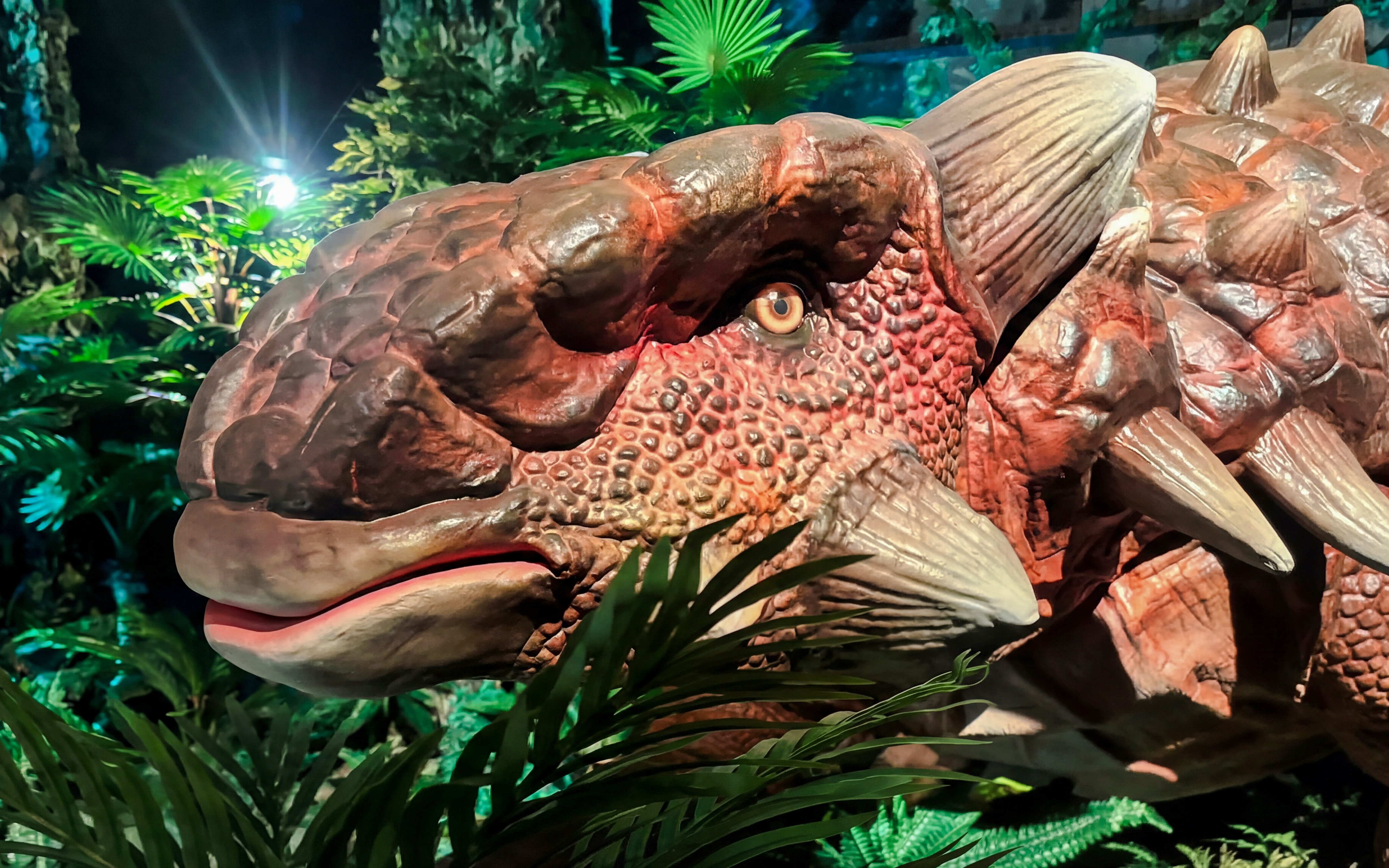 Dinosaur model in lush exhibit at Dinosaurs: The Immersive Odyssey VR Experience.