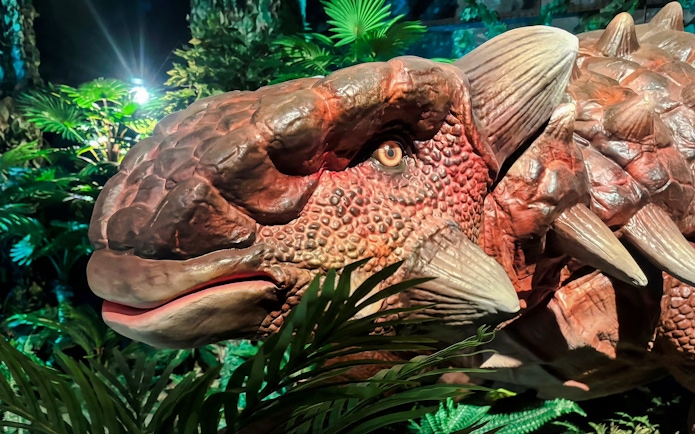 Dinosaur model in lush exhibit at Dinosaurs: The Immersive Odyssey VR Experience.