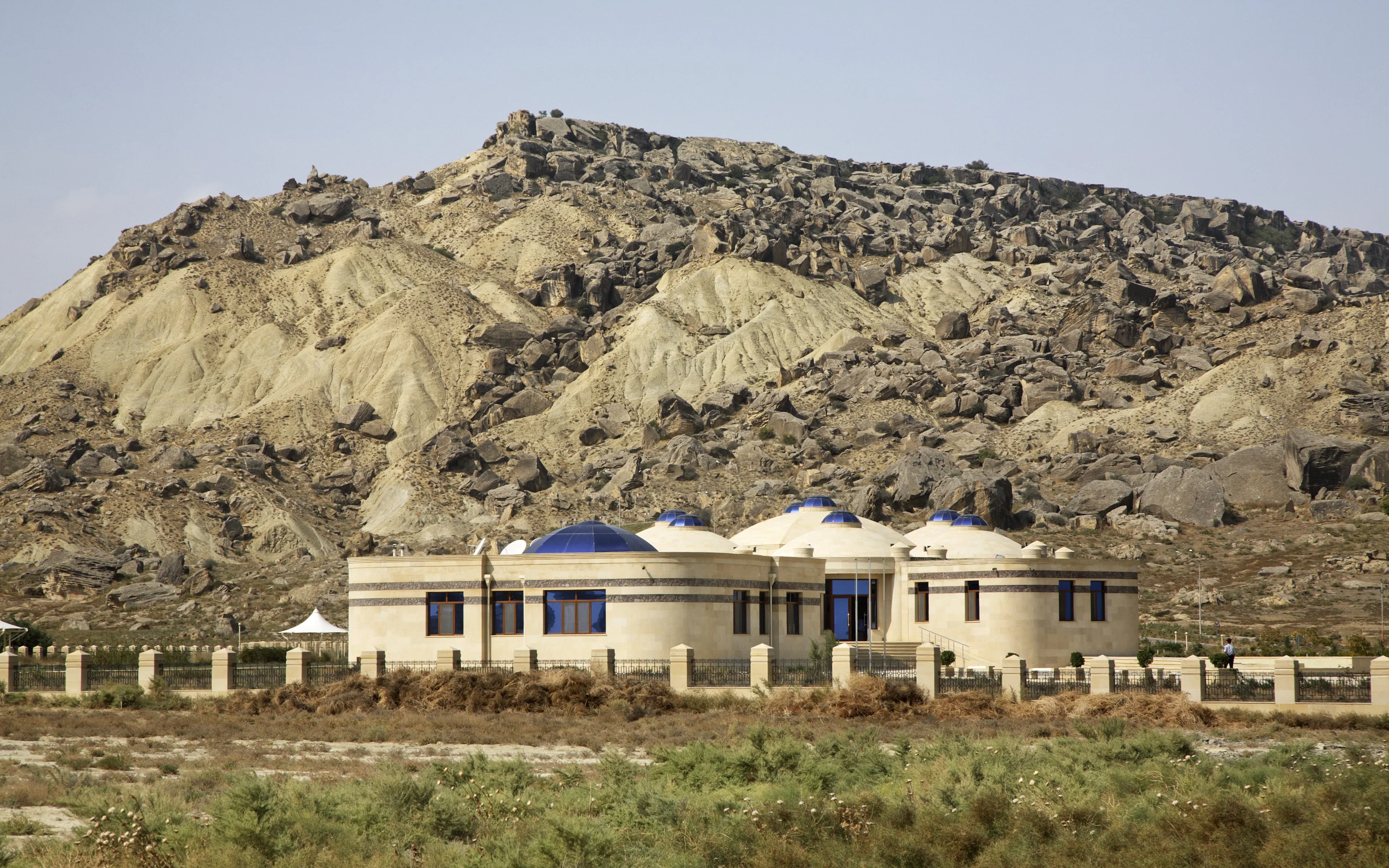Museum building with domed roofs in Gobustan National Park, Azerbaijan, set against rocky hills.
