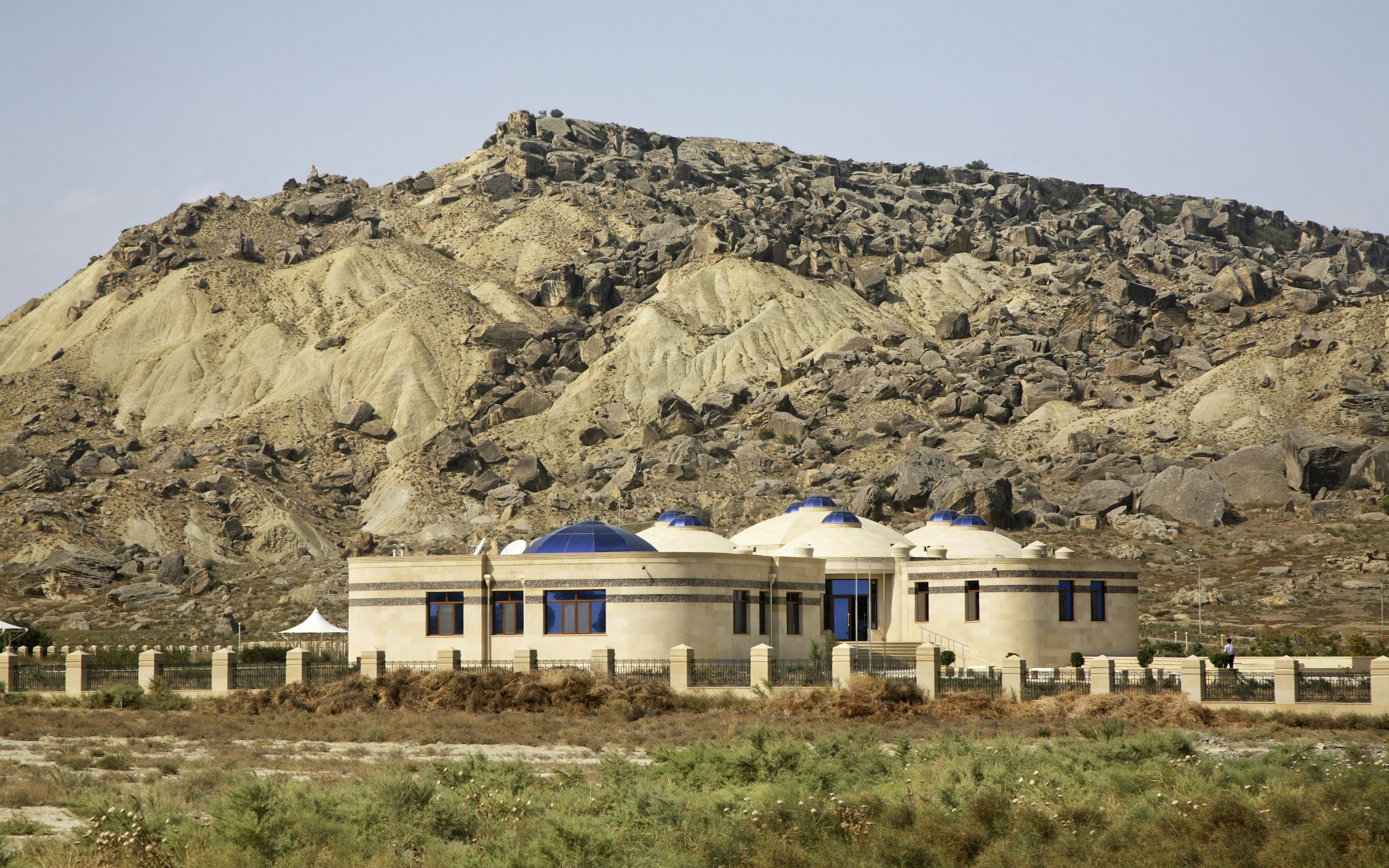Museum building with domed roofs in Gobustan National Park, Azerbaijan, set against rocky hills.