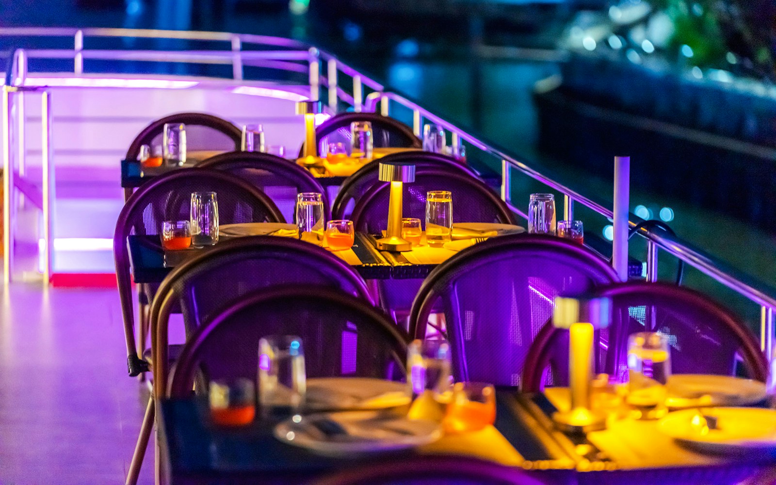 Dining setup on Bangkok Chaophraya Cruise with tables and ambient lighting.