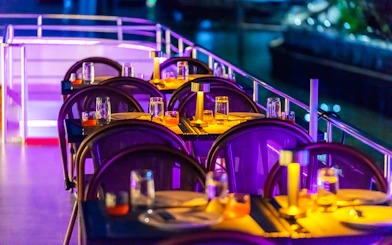 Dining setup on Bangkok Chaophraya Cruise with tables and ambient lighting.
