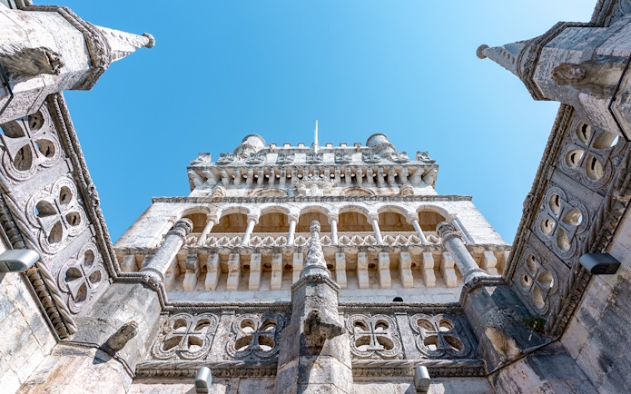 Belém Tower in Lisbon viewed from below, showcasing its ornate architecture.