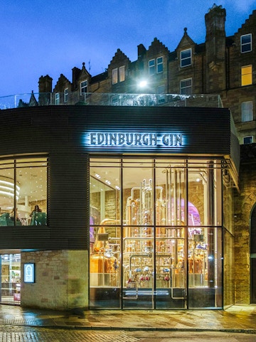 Edinburgh Gin distillery exterior with copper stills visible through glass.
