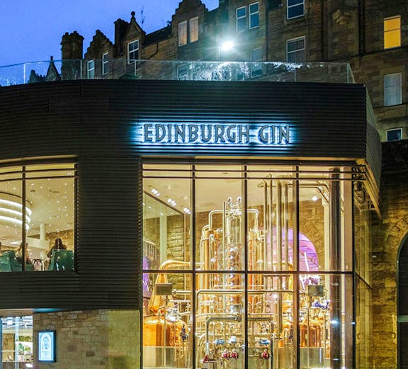 Edinburgh Gin distillery exterior with copper stills visible through glass.