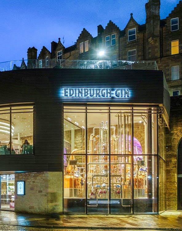 Edinburgh Gin distillery exterior with copper stills visible through glass.