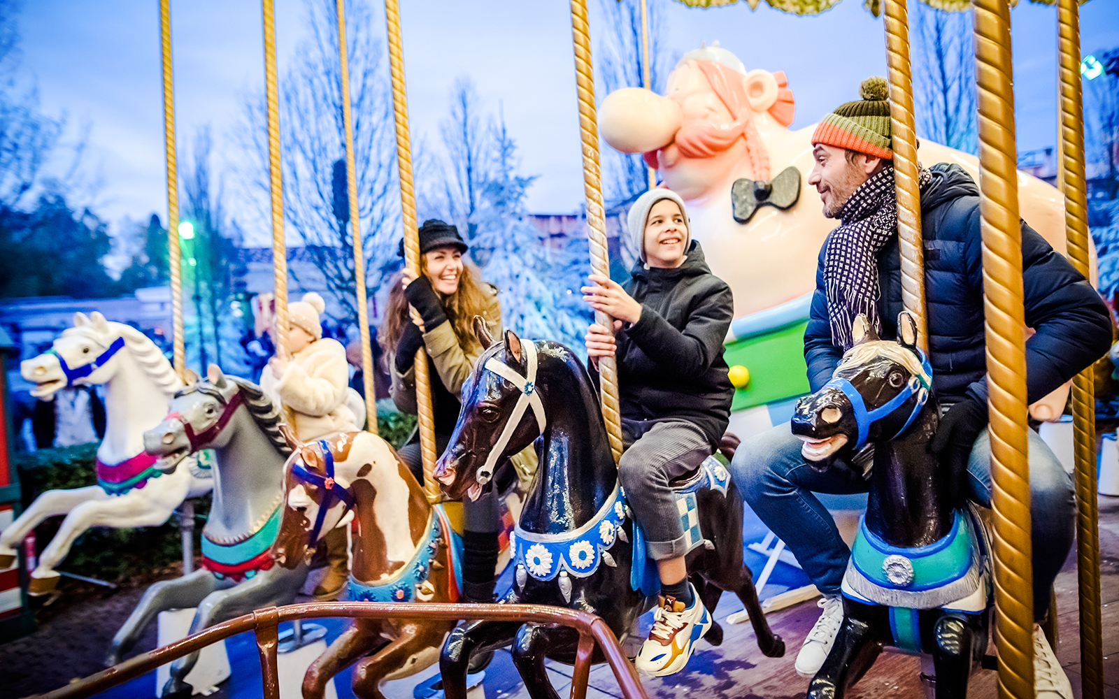 Family enjoying a carousel ride at Parc Asterix during Christmas celebrations.