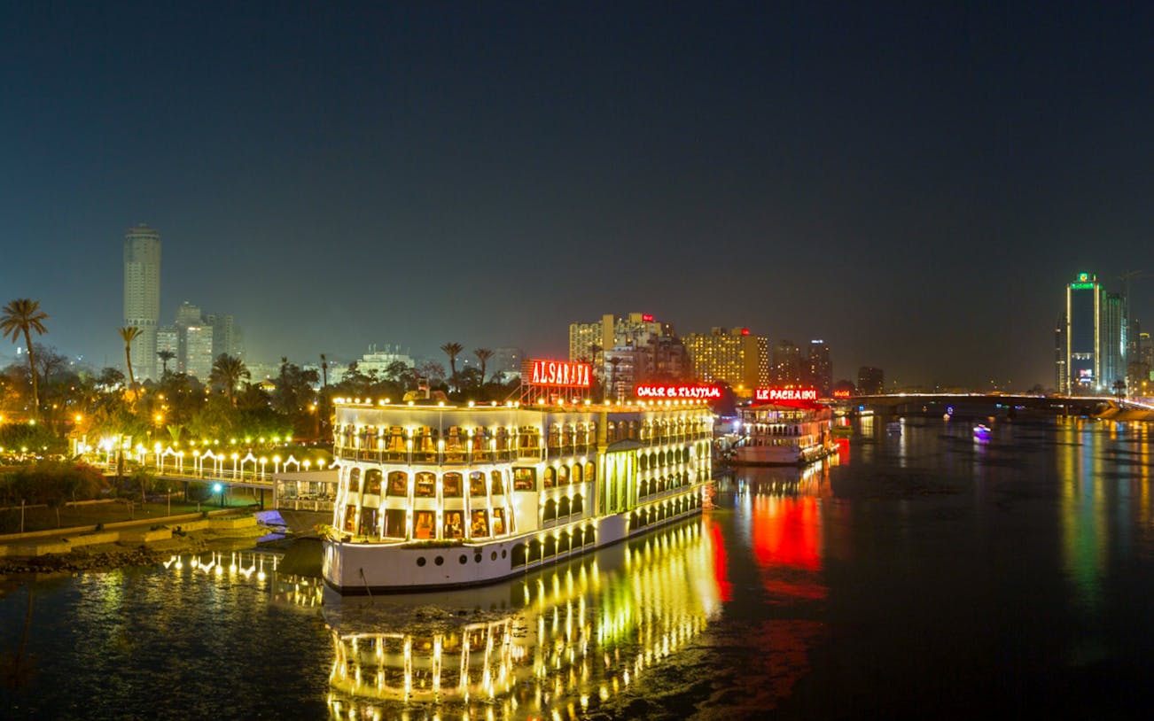 Dinner cruise boat on the Nile River in Cairo with city lights in the background.